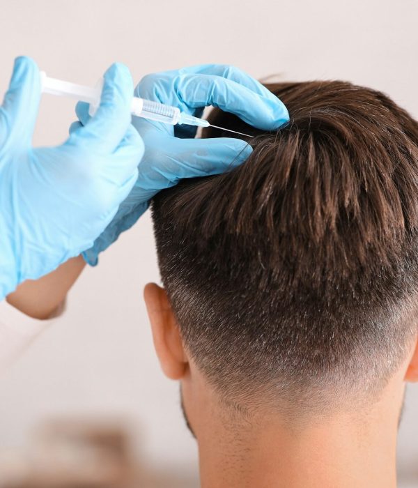 Back view of man having hair treatment at beauty salon